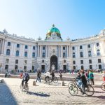 Vienna, Austria - October 1, 2015: tourists on Michaelerplatz square of Hofburg Palace. Michaelertrakt (wing of the Palace) was completed at end of 19th century when old palace theatre was demolished